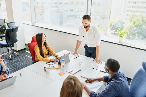 Group of diverse business people meeting at startup office. Businessman explaining business strategy to coworkers during meeting