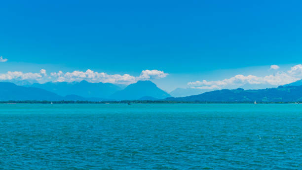 Sailing ship with white sails on a calm lake in the mountains