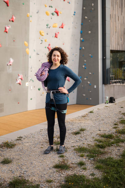 istock Professional female climber standing by outdoor rock climbing wall 1435517182
