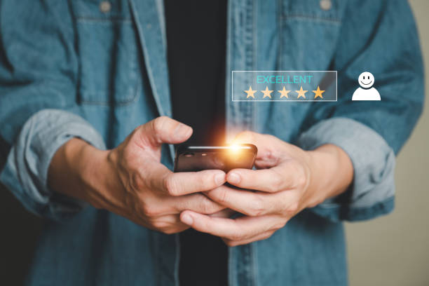 istock Selective focus at human hand while typing on laptop or smartphone to feedback on excellent customer service with five star score with smile. Service evaluation concept with futuristic icon. 1435520406