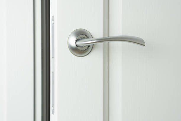 istock Slightly open white wooden interior door with handle and magnetic locking pawl. 1435520523