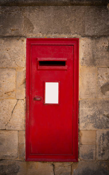istock Oxford red mailbox postbox in stone wall copy space, England UK 1435522129