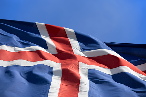 National flags of UK, USA and France against blue sky