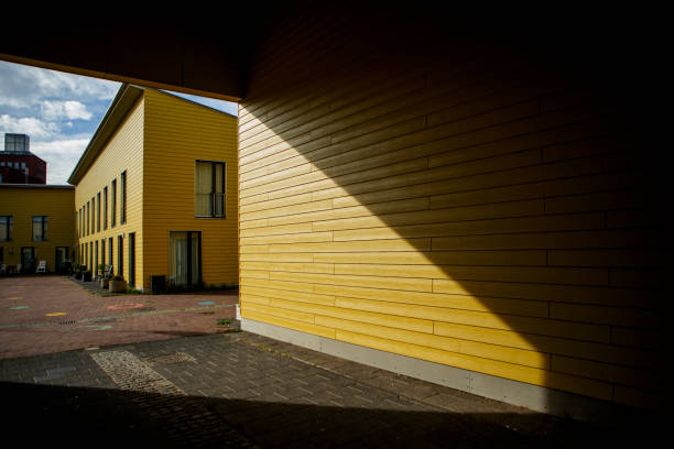 bright yellow gas pipe runs along the wall of a multi-story building, a vital urban utility