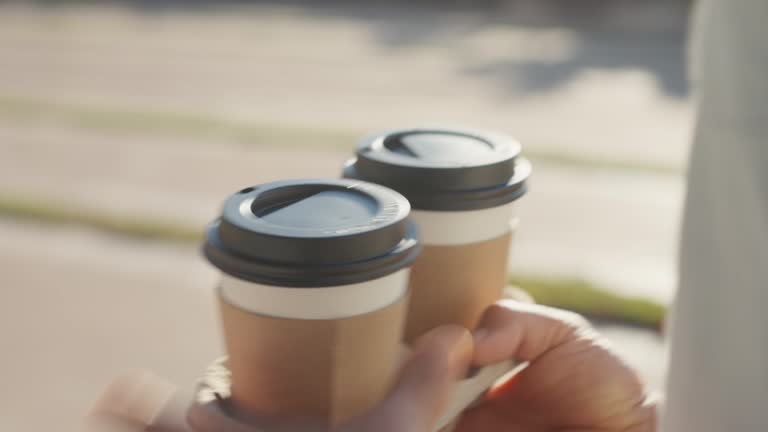 Need more coffee today. Close up cropped man holding in hand holder two takeaway clear empty blank cup coffee. Service concept.