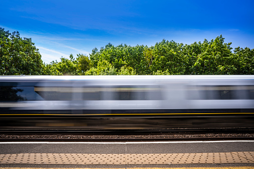 Motion blurred train in London area of UK in a sunny summer day at England Great Britain