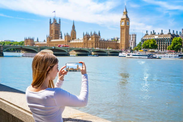 London tourist student young woman smartphone photos Big Ben & Westminster bridge London tourist student young woman shooting smartphone photos at Big Ben tower, Westminster bridge over Thames river England UK westminster bridge stock pictures, royalty-free photos & images