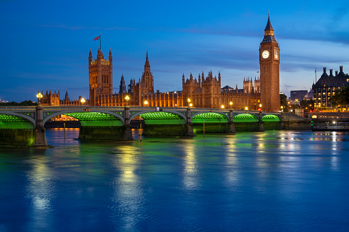 London Big Ben and Houses of Parliament in Westminster Bridge on river Thames at sunset lights in UK Great Britain United Kingdom, England at the evening dusk