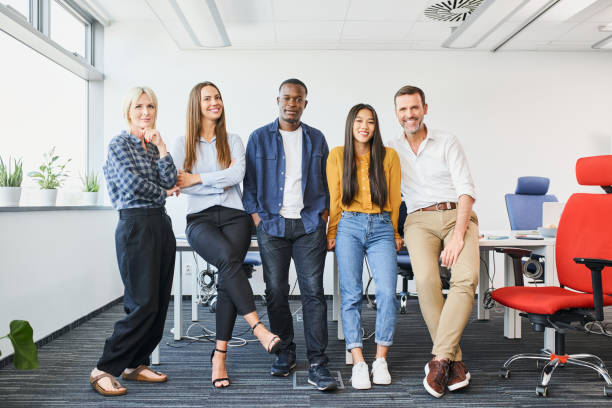 istock Successful diverse business people standing together at startup office. Multi-ethnic happy group of coworkers 1435530744