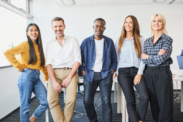 Portrait of successful diverse business people standing together at startup office. Multi-ethnic happy group of people stock photo