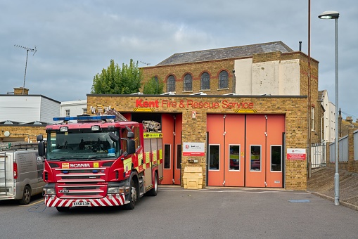 Margate, United Kingdom – October 05, 2022: The Kent Fire and Rescue Service building with orange doors, red fire truck in front, ready to go in Margate, Thanet