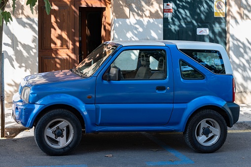 Palma, Spain – August 06, 2022: A nice blue off-road car parked on the street, Suzuki Jimny side view