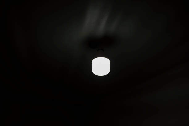 istock Lamp on ceiling. Light in dark room. Lamp is in interior. 1435534556