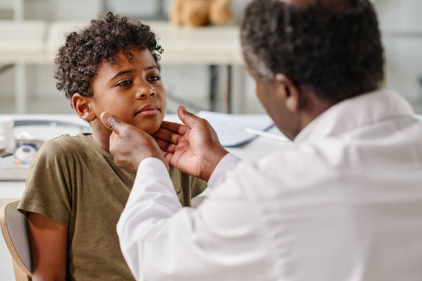Pediatrician examining sore throat of boy African little boy visiting pediatrician at hospital, he complaining on his sore throat sore throat stock pictures, royalty-free photos & images