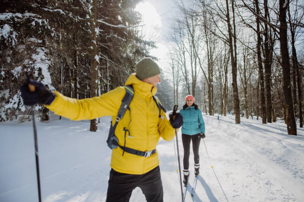 森の真ん中で一緒にスキーをする先輩夫婦 - mens cross country skiing ストックフォトと画像