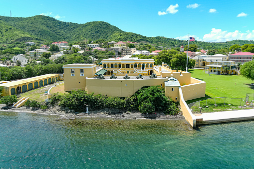 Marigot, Collectivity of Saint Martin / Collectivité de Saint-Martin, French Caribbean: bastion with old French cannons at Fort Saint-Louis, built during the reign of King Louis XVI, wealthy Marigot was a frequent target for looters and buccaneers from Anguilla - panoramic view over the town, Marigot and Nettlé bays, Sandy Ground isthmus and in the background Simpson Bay lagoon.