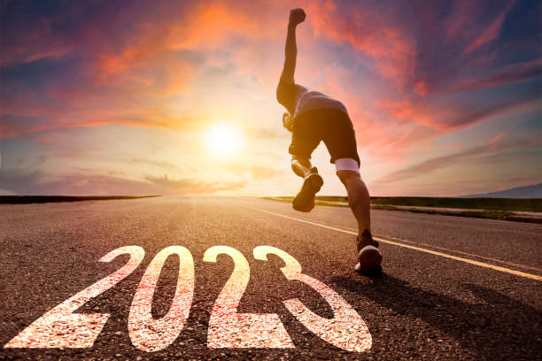 Young man running and sprinting on the road with new year 2023 concept stock photo
