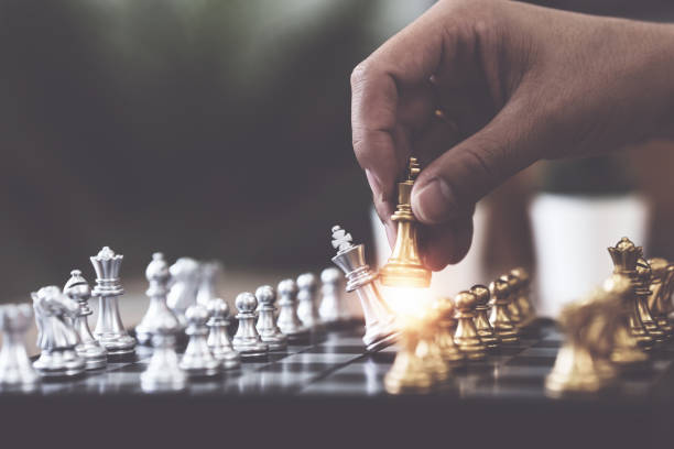 istock Businessman playing or moving chess figure in competition success play 1435558588