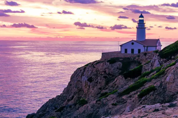 Cape Capdepera with glowing lighthouse at sunset on the island of Mallorca