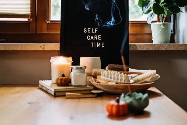 Self-care, Wellness in autumn, winter cold season. Letter board text Self Care Time, aroma sticks, body and self-care handmade cosmetics and beauty product and decor pumpkins.