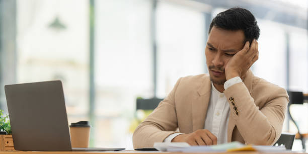 istock Stressed Asian businessman worry with many document on desk at office 1435561911