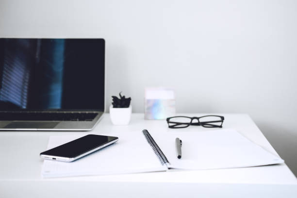 istock Online business ideas. Starting Small Business Online. Modern workspace with blank screen laptop, cell phone, pencil, on white work table. 1435575316