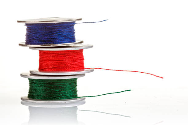 spools of thread in blue, red, green colors on a white background close-up