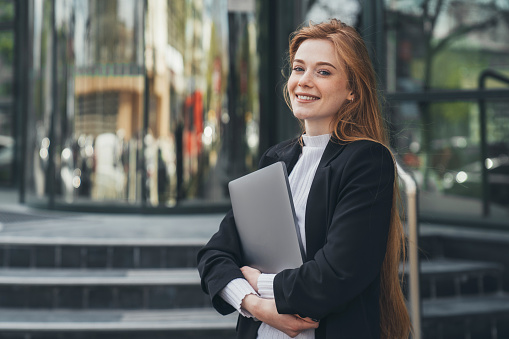 https://media.istockphoto.com/id/1435578008/photo/confident-businesswoman-model-holding-laptop-looking-at-camera-smiling-toothy-standing.jpg?b=1&s=170667a&w=0&k=20&c=_XgeMFIK_o10Ckkw8eBQL6SBEtKBUnQC7NGbTHFguz0=