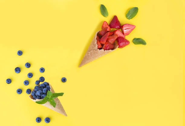 istock Ice cream cone with berry on the yellow background. Top view. Copy space. 1435582648