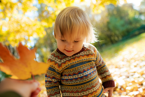 Cute baby girl with her mother enjoying a warm autumn day