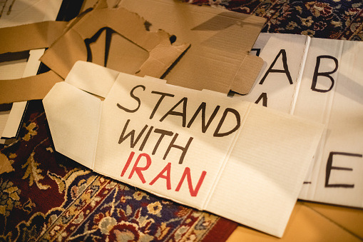 Paper banner for protest. Peace demonstration of people for support human rights and feminism. Female rights and girl power concept, preparations for marching. Text Stand with Iran