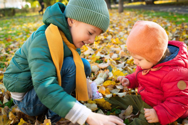 istock Kids playing together in autumn park 1435587189
