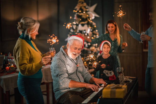 reunião da família multigeração para celebração de natal e tocar piano - caroler - fotografias e filmes do acervo