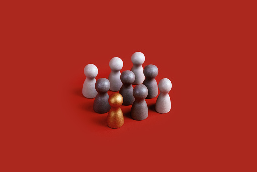 Toy figures on red background. Standing out from the crowd concept.