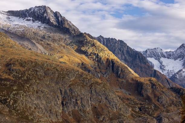istock Peak of a rocky mountain with snow on it under cloudy sky 1435591441