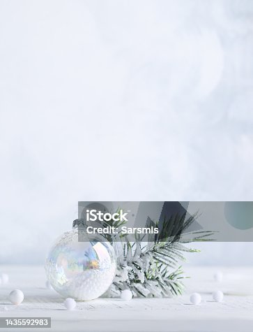 istock Christmas minimalist still life with snowy fir branches and transparent Christmas ball on light background. Winter or Christmas festive concept. 1435592983