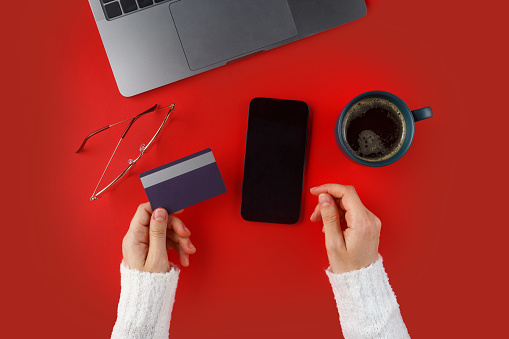 Woman holding credit card in front of the laptop