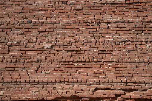 Old rough rugged red brick wall or exterior structure from 1880s gold mining town in Colorado in the town of Victor in western USA of North America.