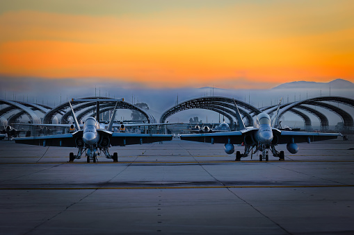 Miramar, California, USA - September 25, 2022: Two US Marine Corps FA-18 Hornets sit on the tarmac at sunrise for the 2022 Miramar Airshow.