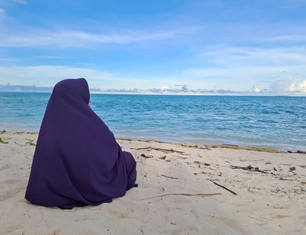 istock Muslim woman on the sunny beach back view 1435601191