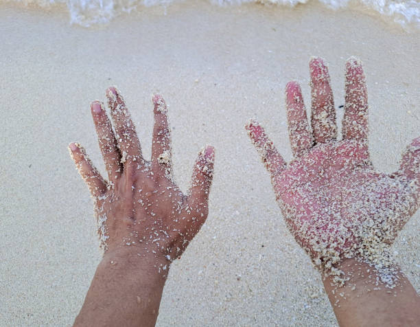 istock hands with grains of sand beach 1435601444