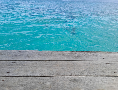 Wooden walkway on the beach. Jetty into the Blue. Wooden texture with beautiful sea background