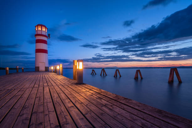 istock Jetty with lighthouse at calm lake in the evening 1435603310