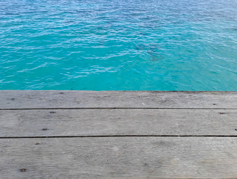 Wooden walkway on the beach. Jetty into the Blue. Wooden texture with beautiful sea background
