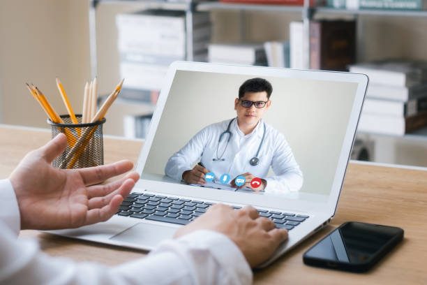 istock Concepts of online medicine, communicating with patients through online networks, technology and healthcare. Make a video call with a doctor on your laptop. 1435606204