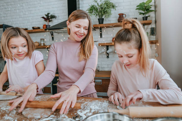 istock Mother with daughters cooking Christmas gingerbread cookies 1435606564