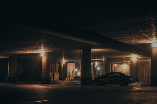 Interior of parking garage with car and vacant parking lot in parking building