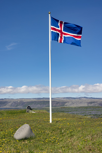 Iceland flag near beautiful coast of South Iceland