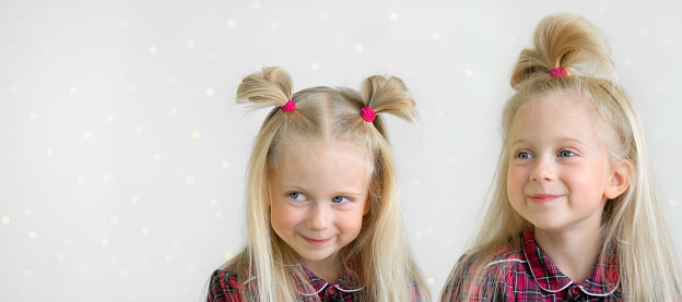 Two smiling girls in the plaid shirts. Collage from two photos of one girl.