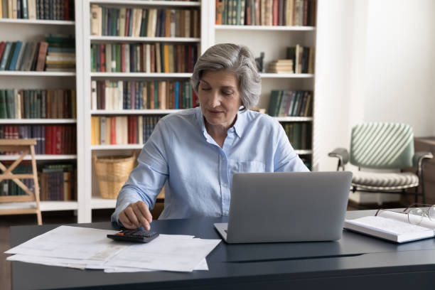 istock Accountant working seated at workplace desk with laptop and bills 1435621286